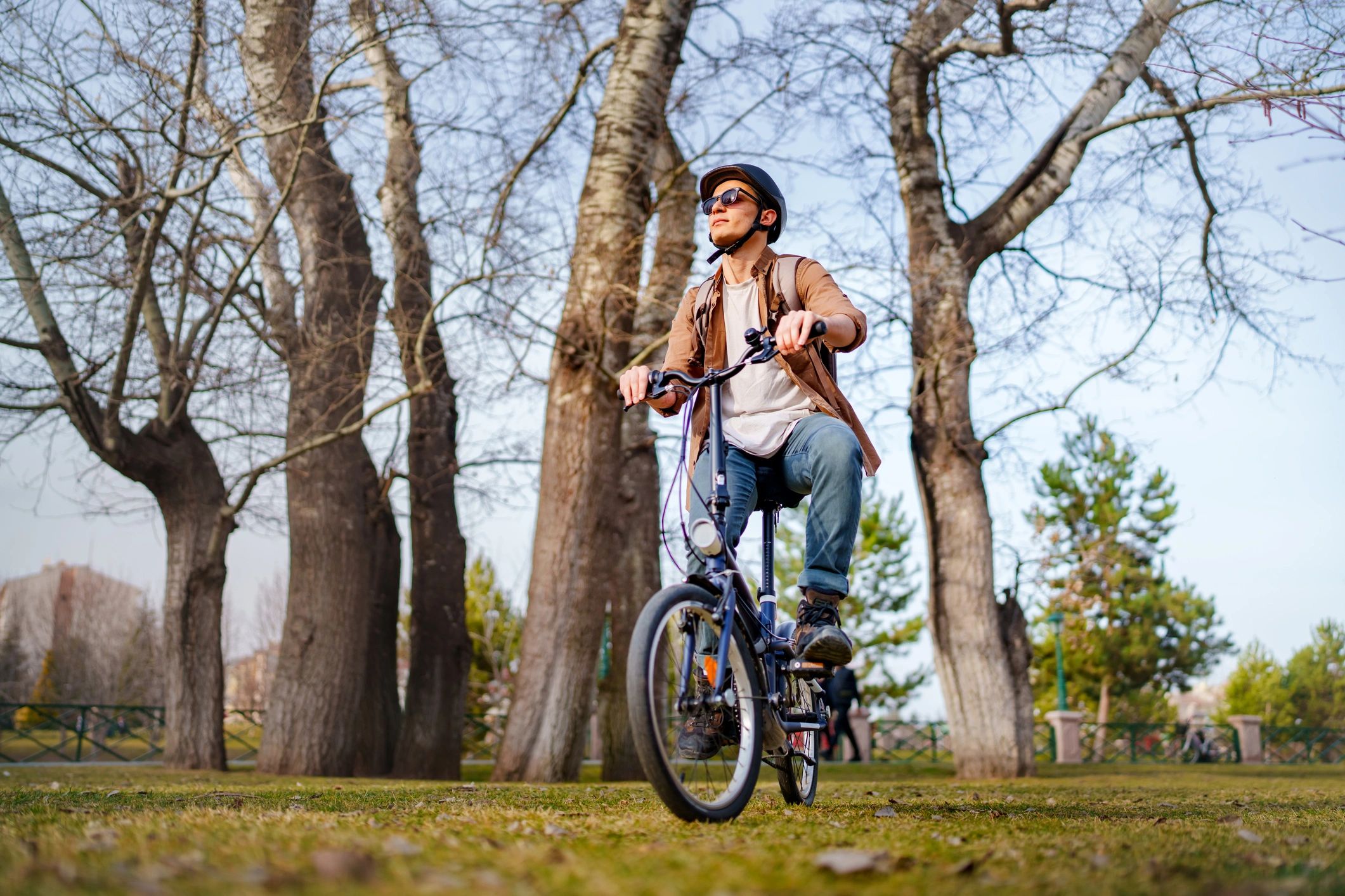 Helmeted cyclist riding through a park trail